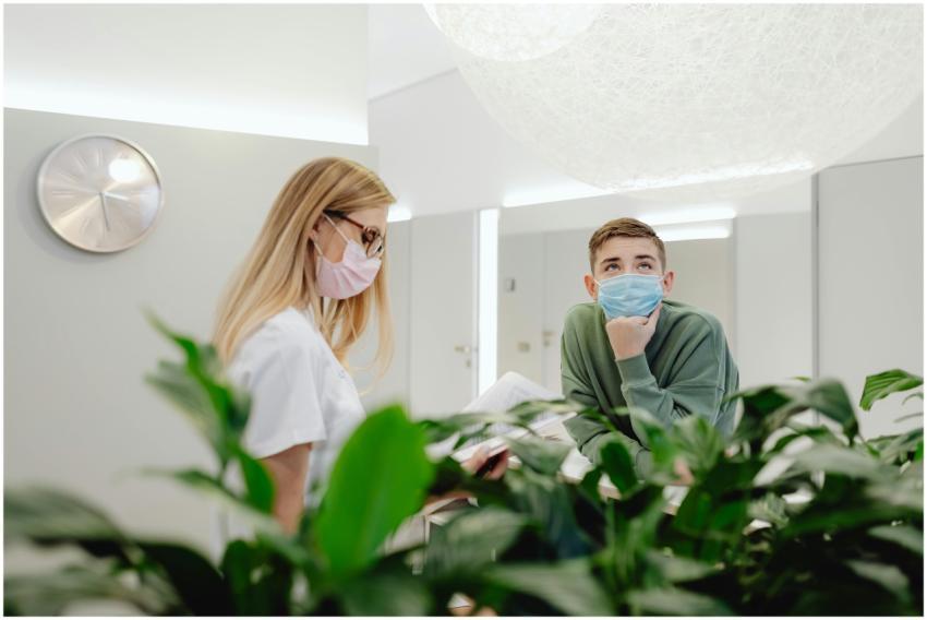 Nurse and patient wearing face masks in a modern c