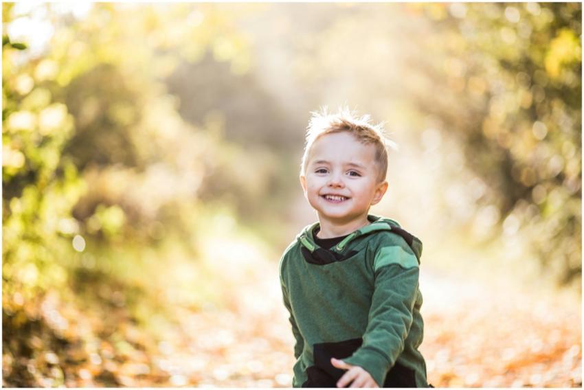 A happy young boy enjoying a sunny autumn day outd