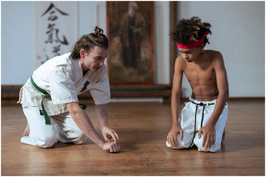 A karate instructor teaching a young student marti