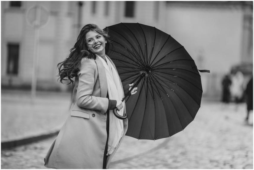 Stylish woman with umbrella, captured on city stre