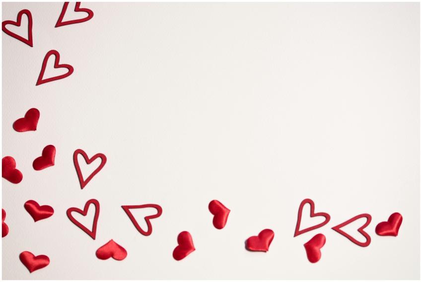 Red hearts scattered on a white background, ideal