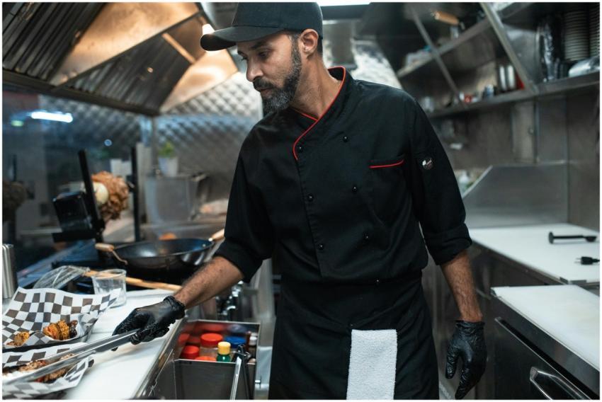 A chef in a food truck kitchen preparing street fo