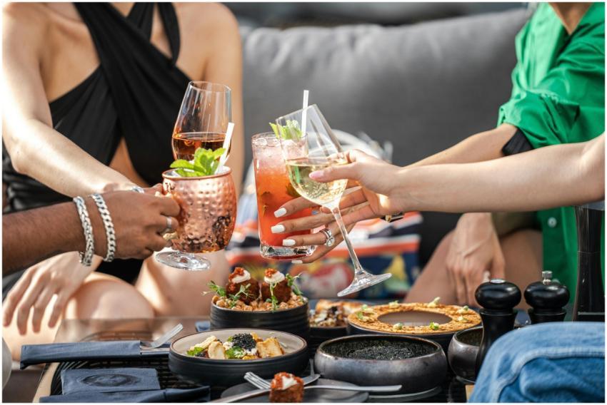 Friends toasting with cocktails at an outdoor gath