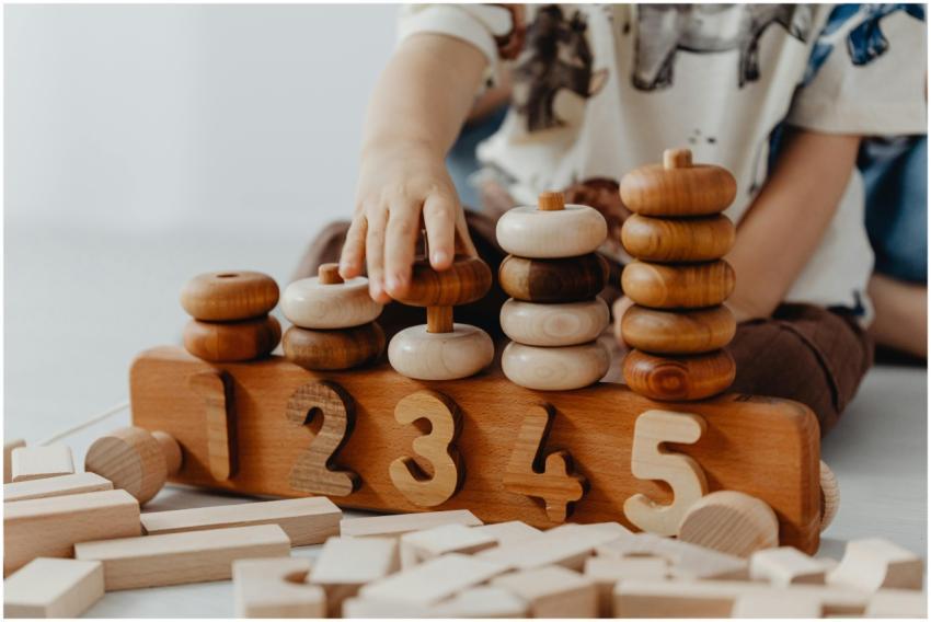Child's hand interacting with wooden educational t