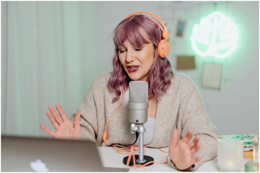 Woman podcasting indoors with headphones and micro