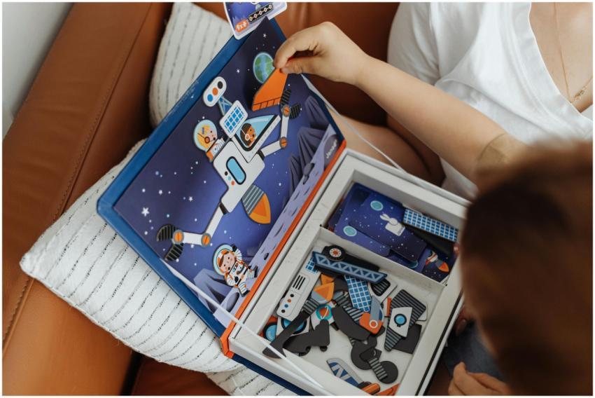 Child engaged in assembling a colorful space-theme