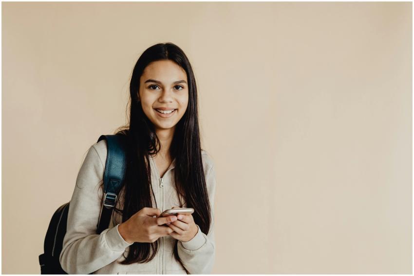 Teen girl with backpack using a smartphone against