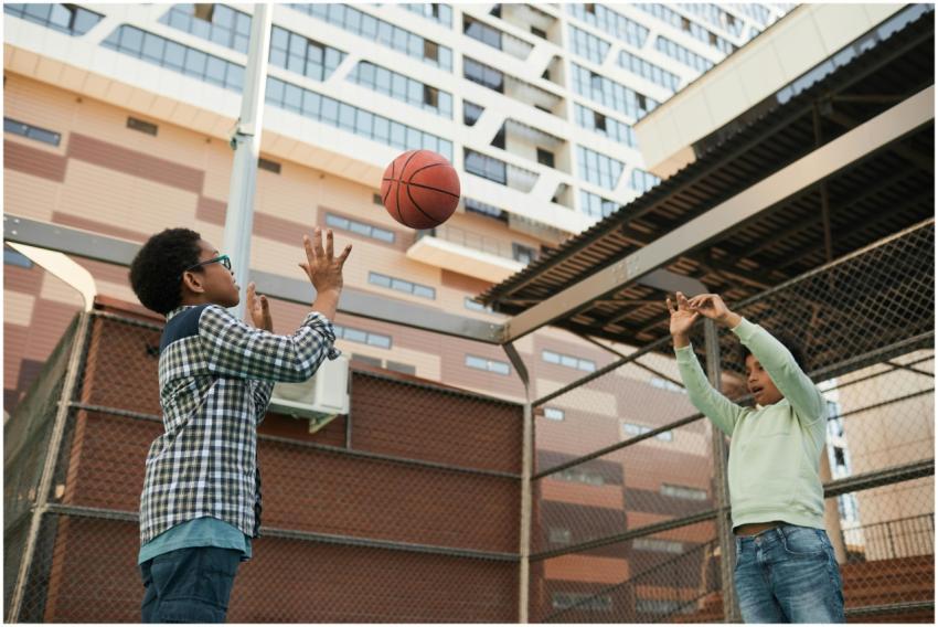 Two boys playing basketball on an urban outdoor co