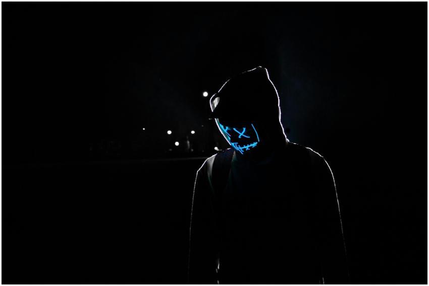 Silhouette of a person in a hoodie wearing a glowi