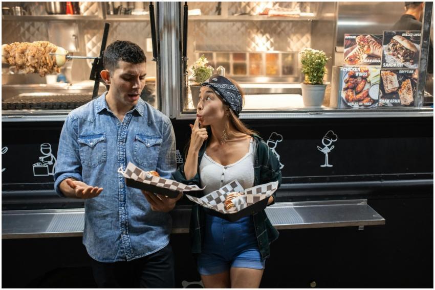 A couple enjoys street food from a food truck at n
