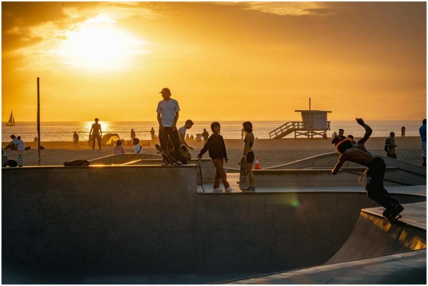 Skaters enjoying a sunset at a beachfront skate pa