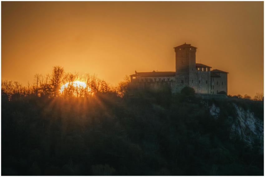 Majestic castle silhouette against a vibrant sunse