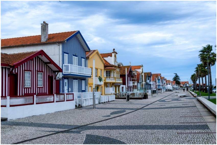 Vibrant striped cottages lining a coastal promenad