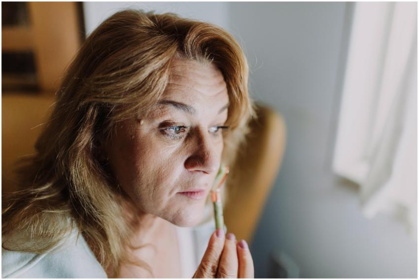 A woman applying a skincare product indoors, focus