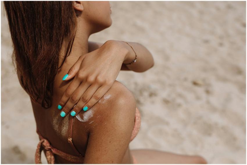 Close-up of a woman applying sunblock on her shoul