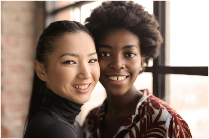 Close-up of two diverse women smiling together ind