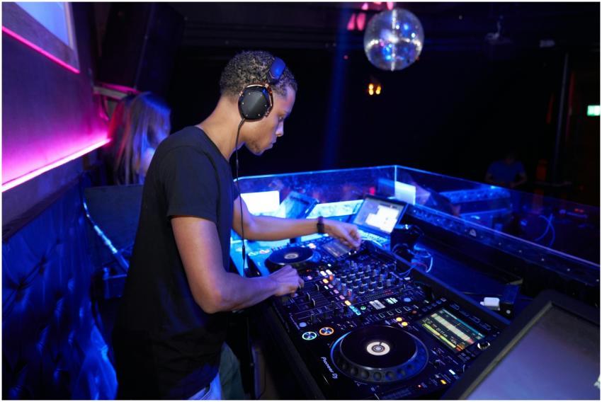 DJ mixes music at a vibrant nightclub with disco l