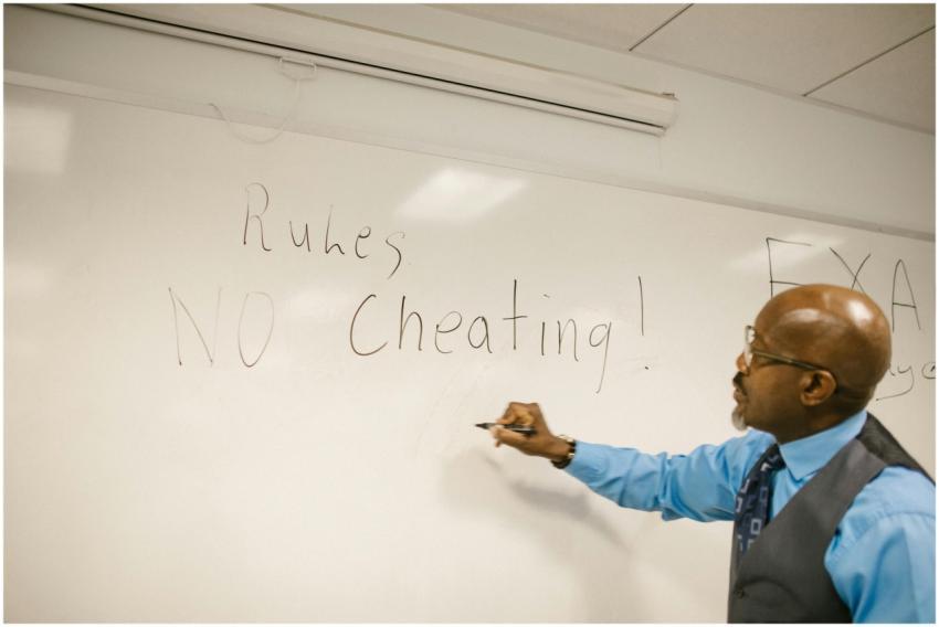 Teacher writes 'No Cheating!' on whiteboard during