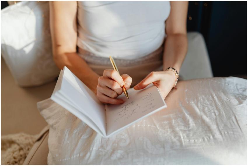 Close-up of a woman writing in a journal while sit