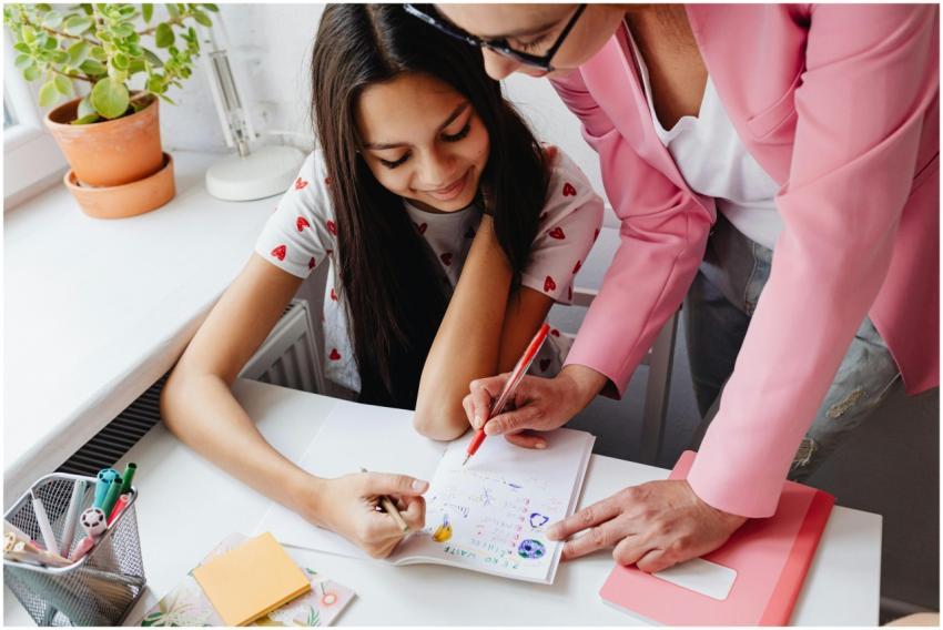 A teacher guiding a teenager through homework at a