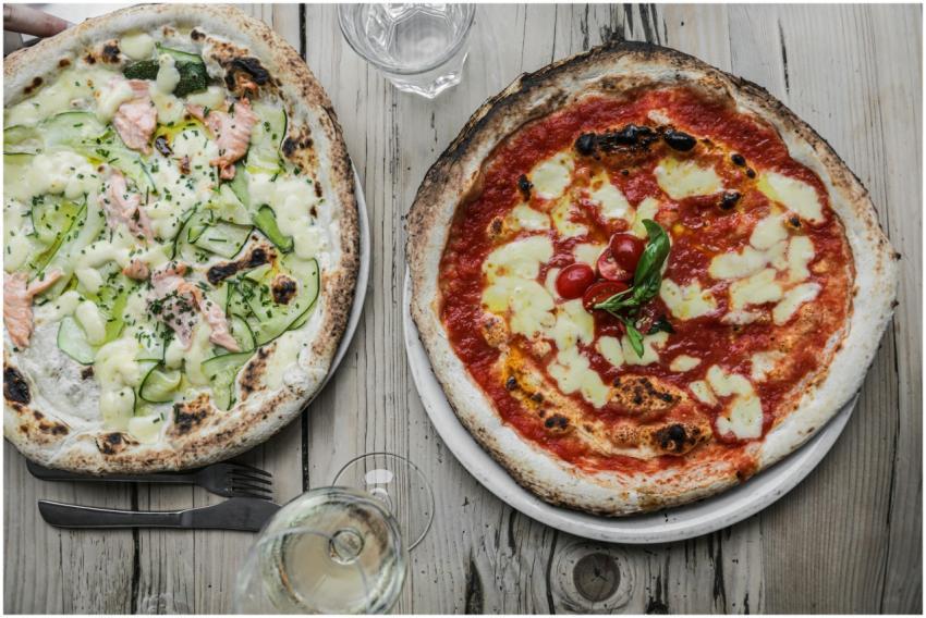 Two gourmet pizzas with unique toppings: salmon wi