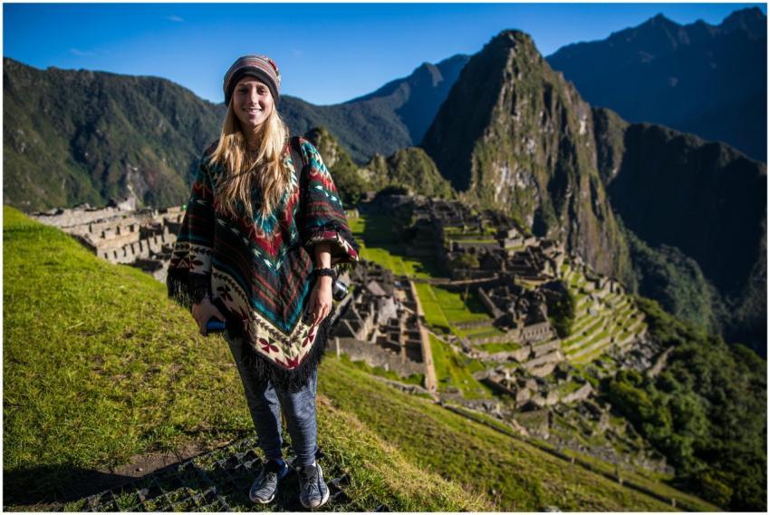 Smiling woman in a poncho at Machu Picchu with mou