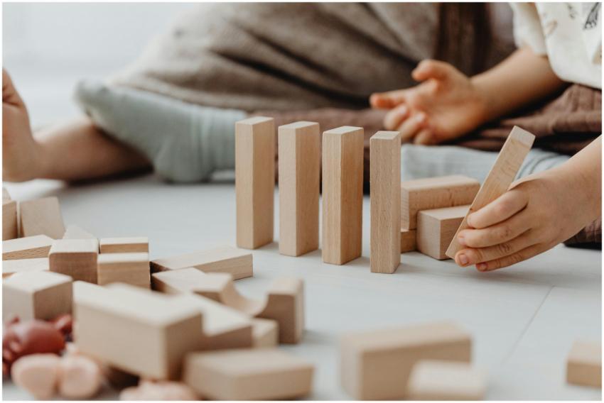 Young child engaging with wooden blocks, encouragi