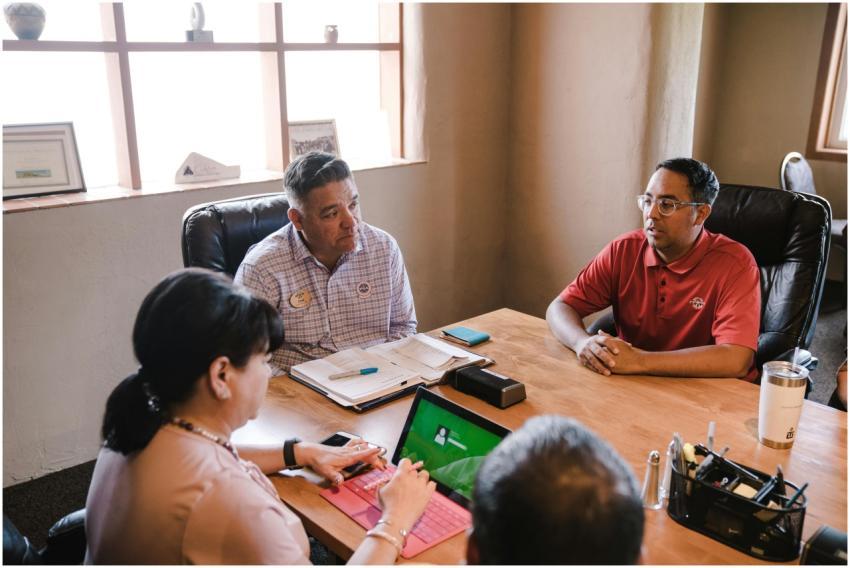 Colleagues discuss ideas in an office setting, emp