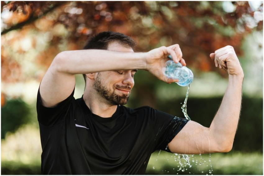 Man pouring water over himself during an outdoor w