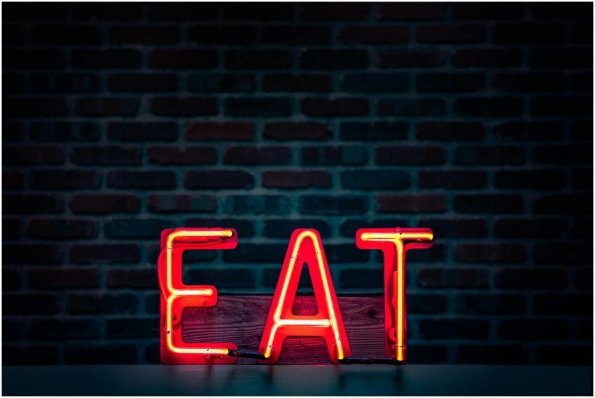 Vibrant neon 'EAT' sign in red glowing boldly agai