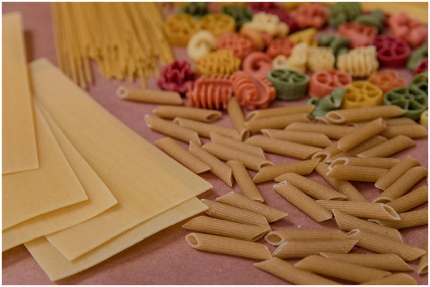 Assorted uncooked pasta varieties displayed on a w