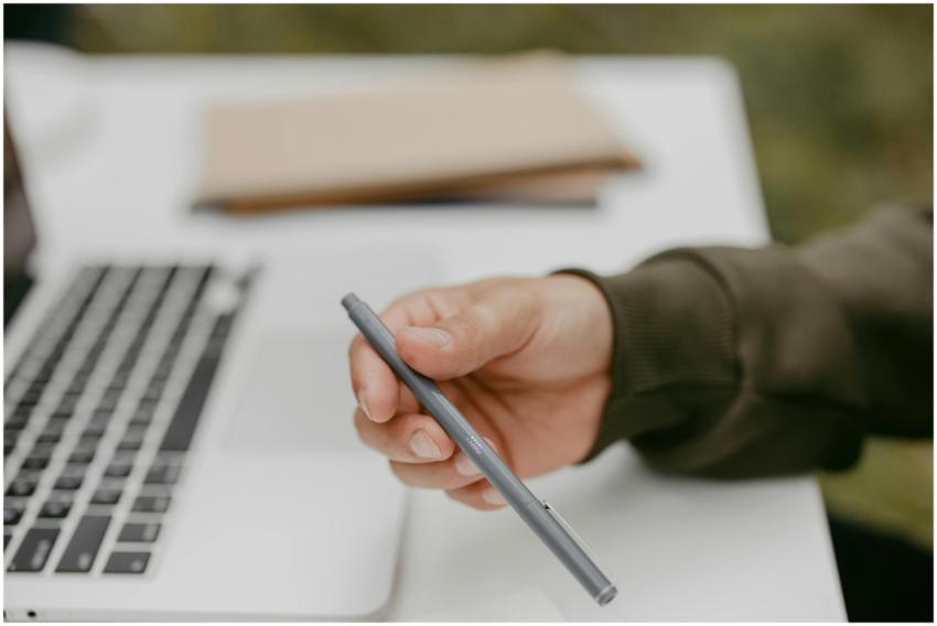 Close-up of a person holding a ballpoint pen near