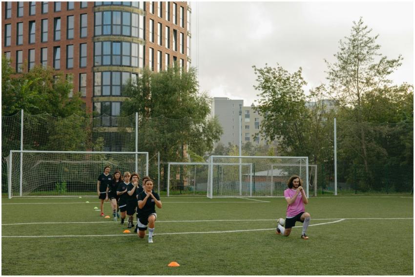 A group of kids performing warm-up exercises with
