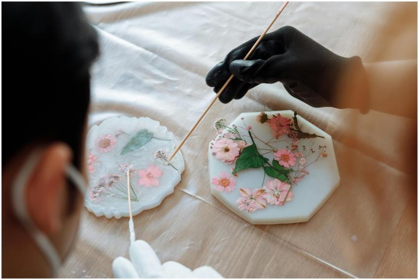 Close-up of hands arranging dried flowers in resin
