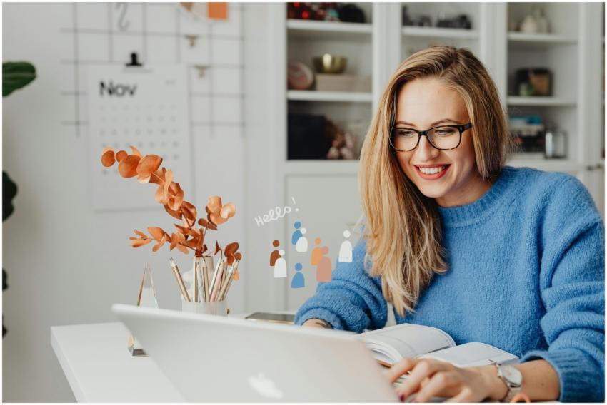 Smiling woman in eyeglasses using a laptop at home