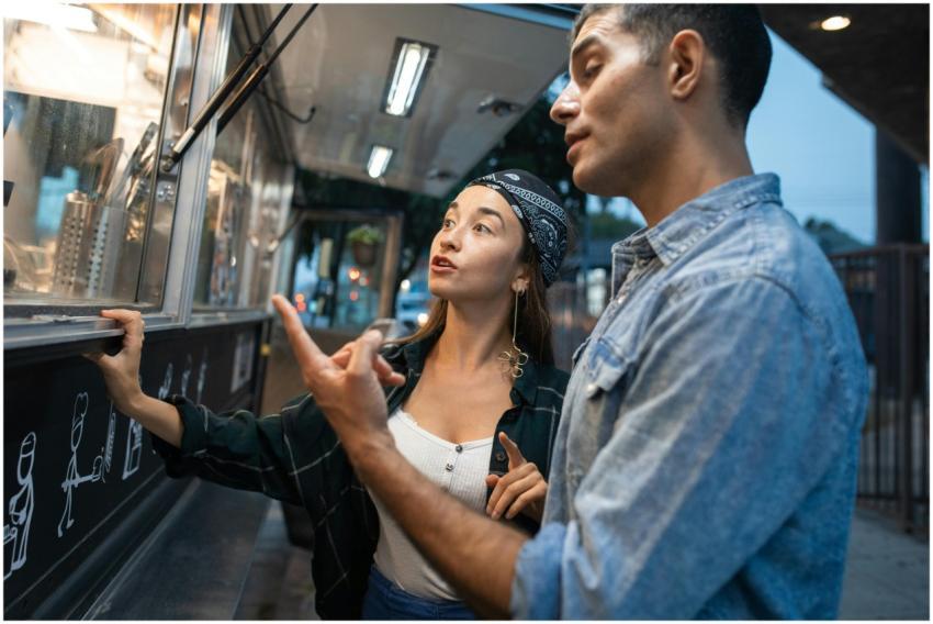 Young couple ordering food from a trendy street tr
