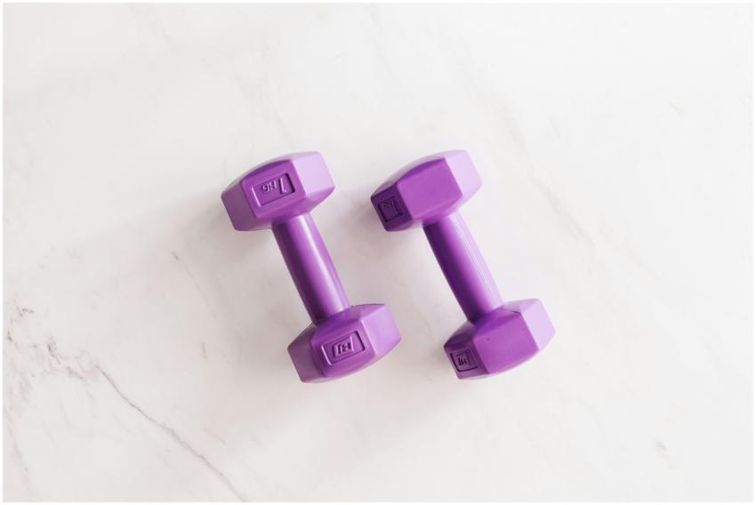 Overhead shot of two purple dumbbells on a white m