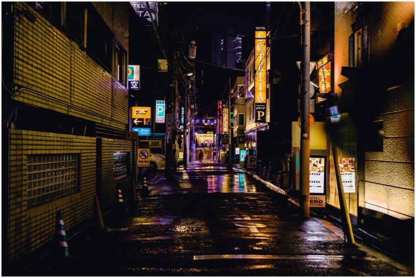 Moody nighttime scene of a Tokyo alleyway with ill