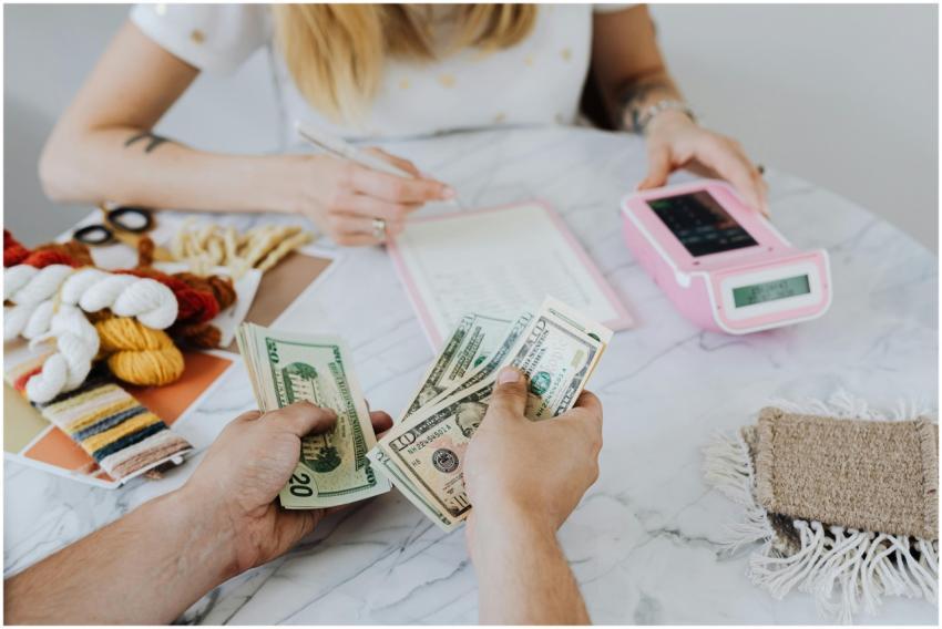 Two people handling cash and budgeting with a calc