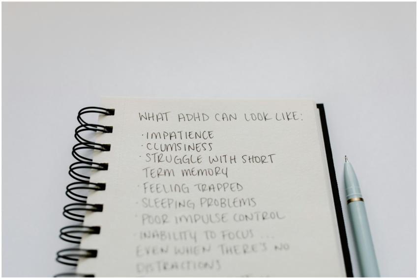 A notebook with handwritten ADHD symptoms like imp