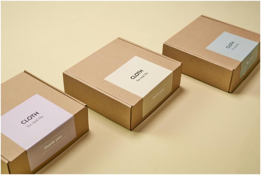 Three minimalist cardboard packages labeled 'CLOTH