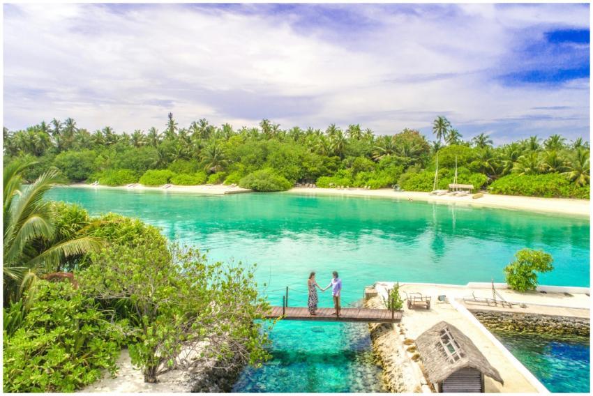 A couple holds hands on a dock overlooking the tur