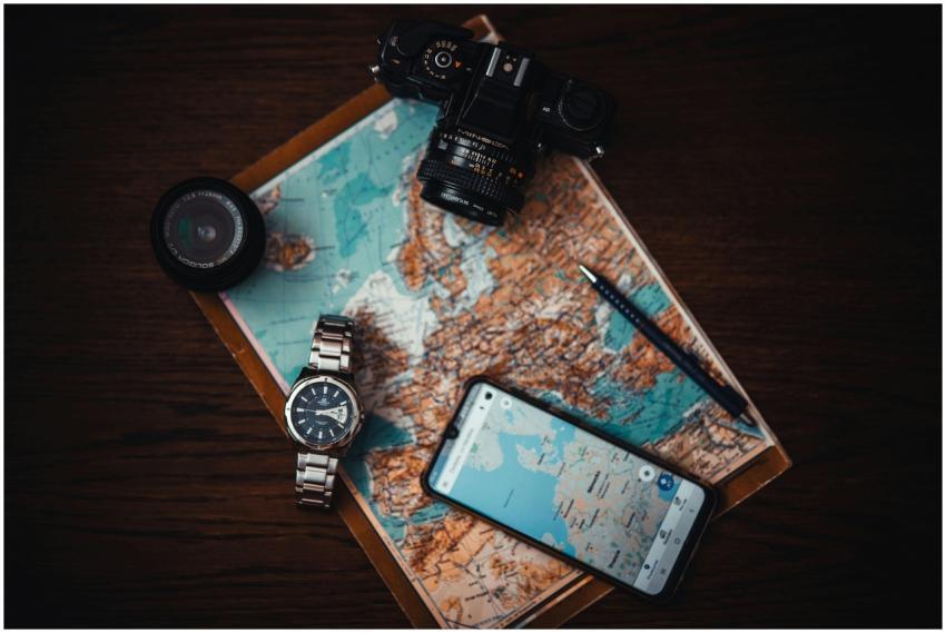 Top view of travel essentials including a map, cam