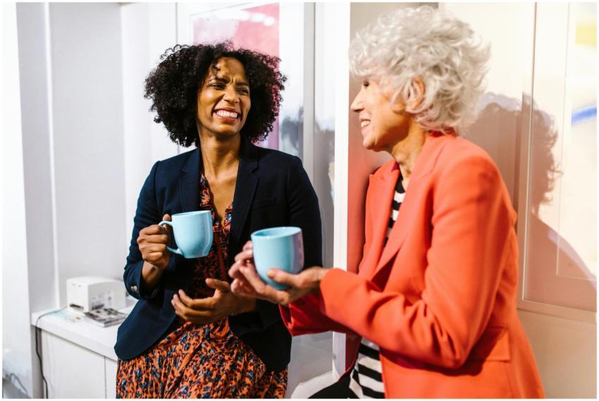 Two diverse women enjoying coffee together in a mo