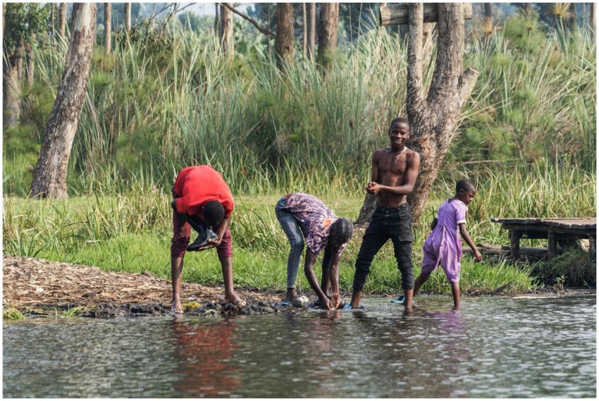 Group of people washing clothes by a serene lake i