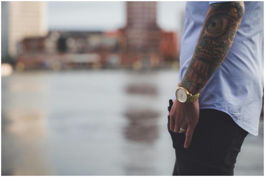 Close-up of a tattooed arm with watch against blur