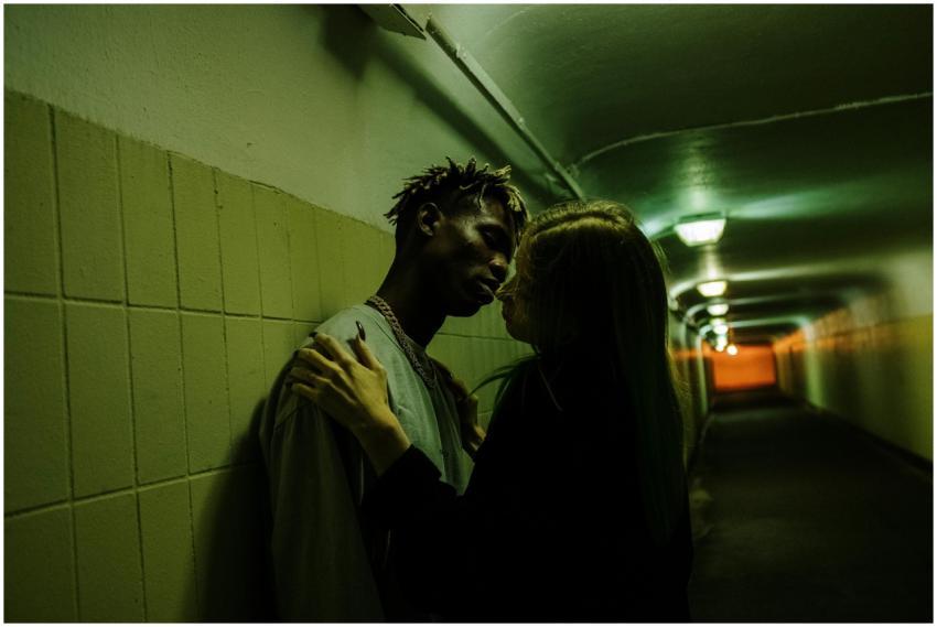 A couple shares an intimate moment in a dimly lit