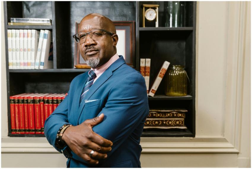 African American man in blue suit with arms crosse