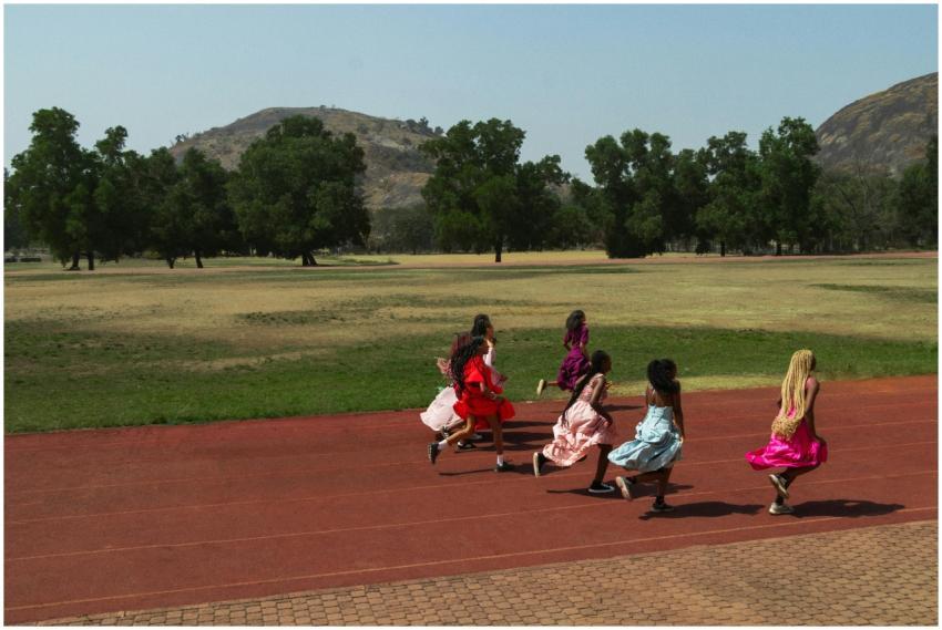 A group of girls wearing colorful dresses running