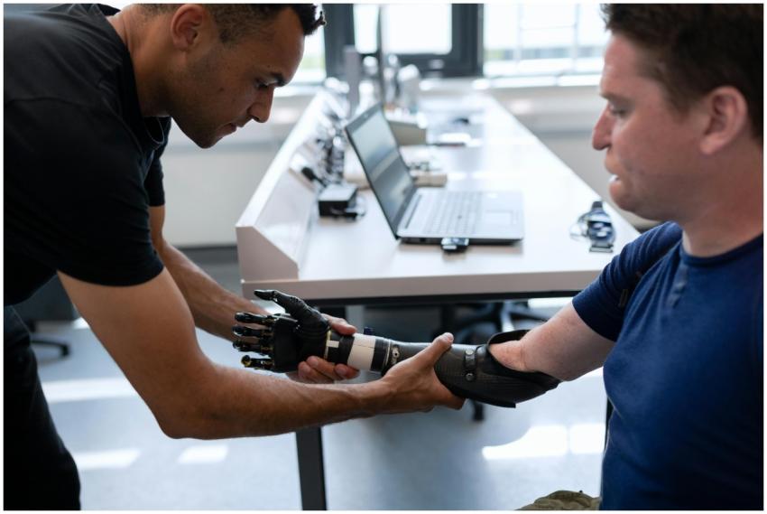 Engineer adjusts prosthetic arm for a patient in a